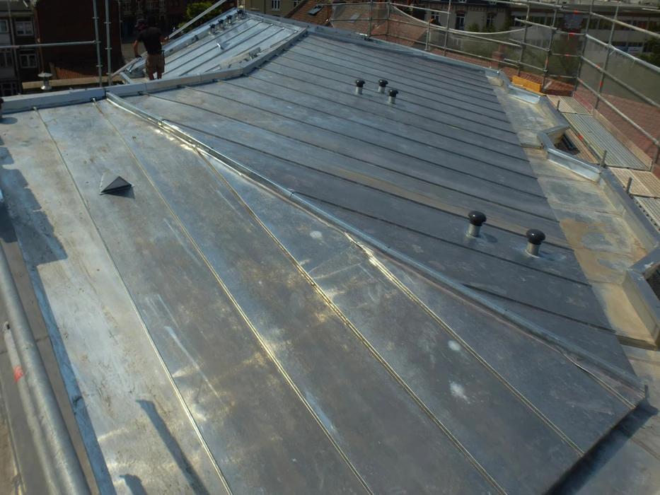 Chantier de toiture en cours, vue aérienne d'un toit plat avec membrane d'étanchéité en cours d'installation