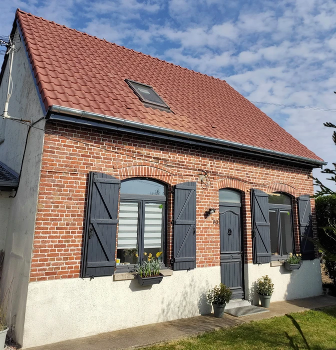 Toiture résidentielle extérieure avec couverture en ardoises grises sous ciel nuageux