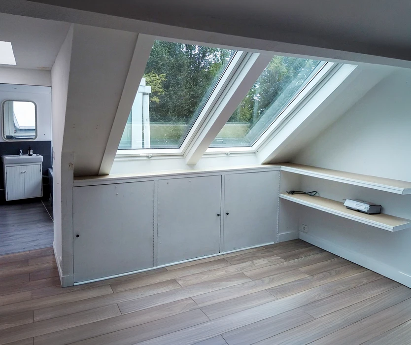 Maison individuelle en brique rouge avec volets battants gris, toiture en tuiles mécaniques terre cuite